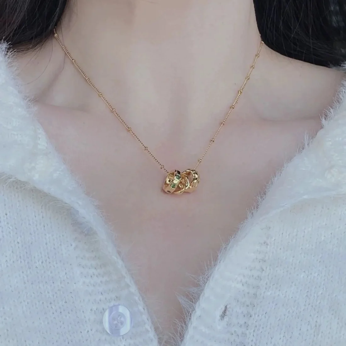Collana con cerchi intrecciati e zirconi verdi